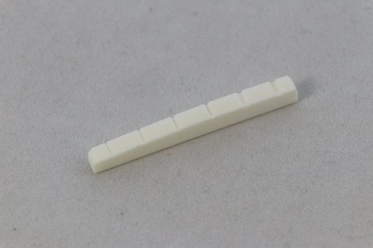 Fender style bleached bone nut, shaped and slotted, 7.5" top radius, flat bottom